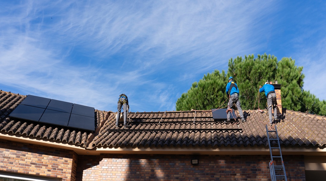 Workers of a solar panel and renewable energy installation company installing solar panels