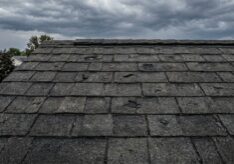 Close-up showing what minor hail damage and granule loss looks like on dark asphalt roof shingles in Columbus, Ohio.